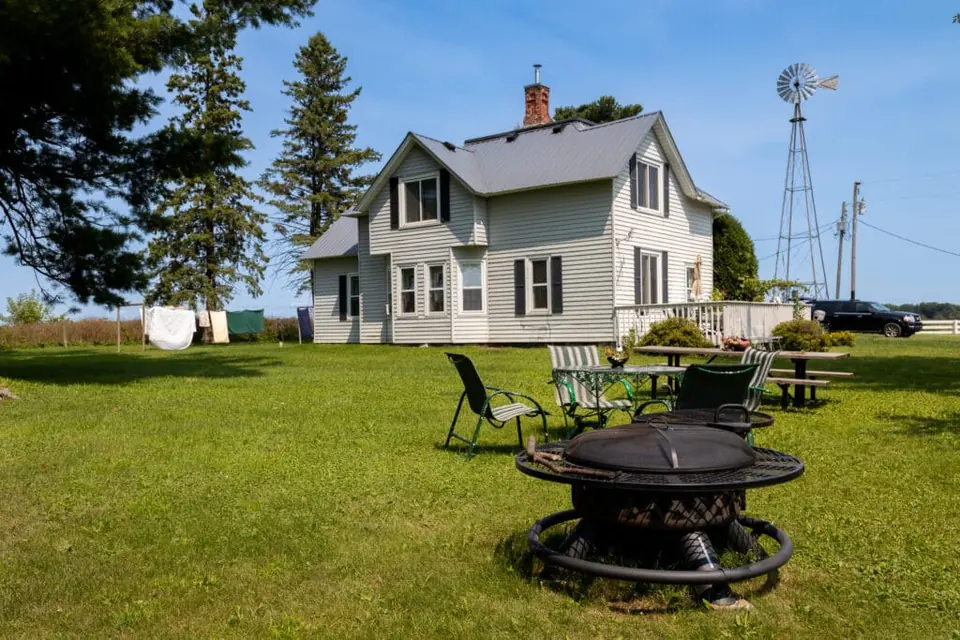 The white historic farmhouse at Longview Farm, with a lawn and outdoor seating