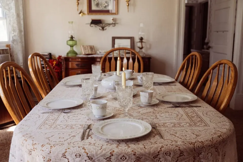 Wooden dining table laid with dishes in the farmhouse