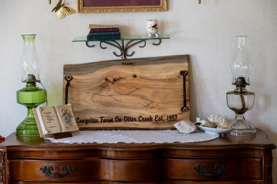 Farmhouse sideboard with family decorations and a wooden Longview Farm board